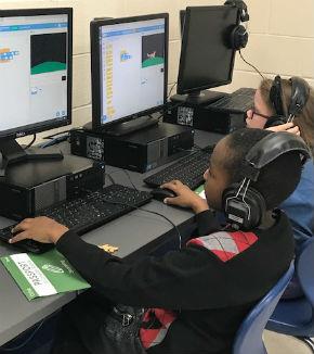 students with headphones coding on computers 